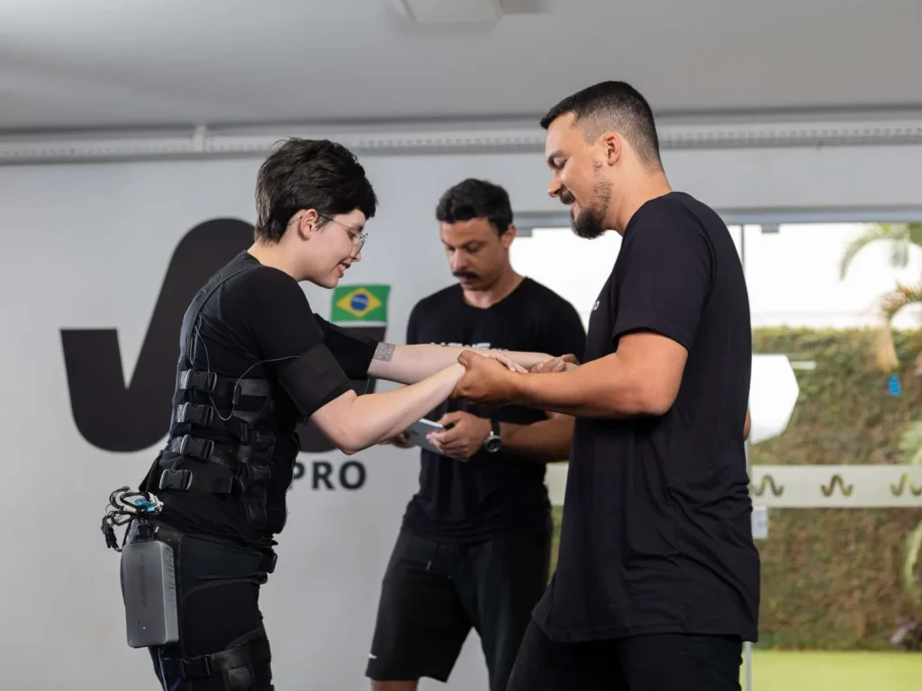 Profissional da WiemsPro ajusta o dispositivo no traje de eletroestimulação de um cliente, na sede da empresa